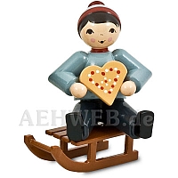 Boy with gingerbread sitting red