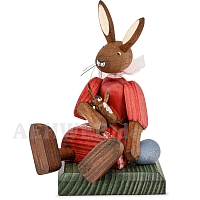 Easter bunny girl sitting with red dress and doll