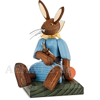 Easter bunny girl sitting with blue dress and doll